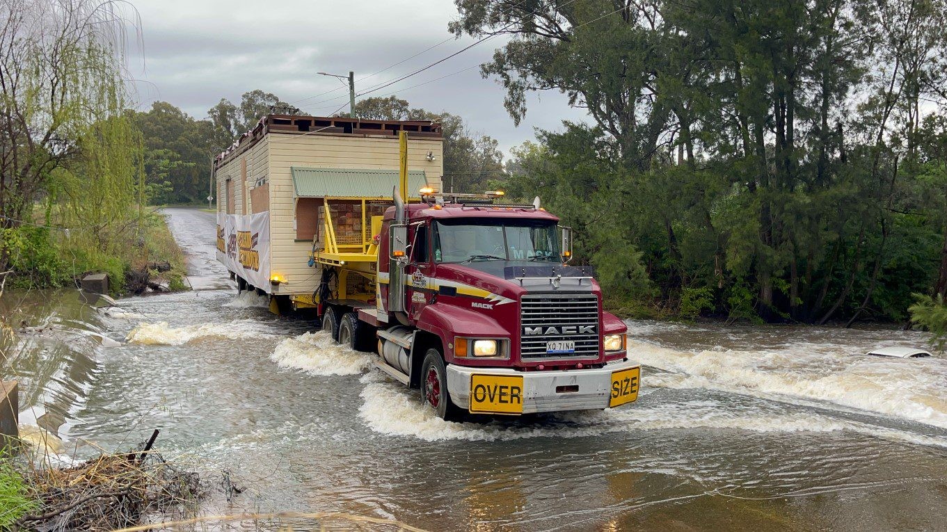 Queensland House Removers doing their thing, with some help from a Mack prime mover.